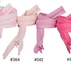 May include: Four different colors of YKK zippers, in pink, light pink, and two shades of rose. The zippers are labeled with their corresponding numbers: #512, #364, #042, and #335.