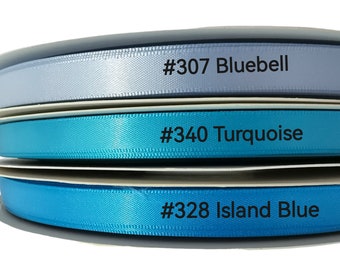 May include: Three spools of ribbon in shades of blue. The top spool is light blue and labeled #307 Bluebell. The middle spool is turquoise and labeled #340 Turquoise. The bottom spool is a darker blue and labeled #328 Island Blue.