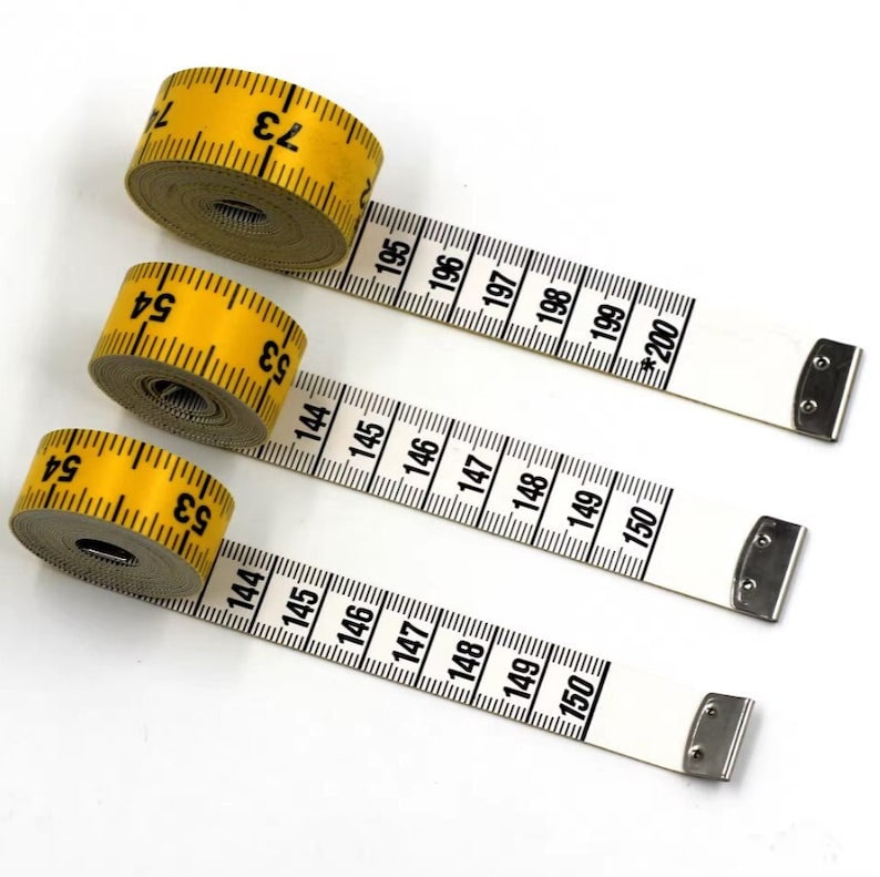 May include: Three yellow measuring tapes with black markings. The tapes are rolled up and the ends are extended. The numbers on the tapes are 53, 54, 73, 144, 145, 146, 147, 148, 149, 150, 195, 196, 197, 198, 199, and *200.