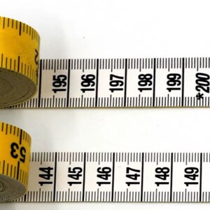 May include: Two yellow measuring tapes with black markings. The top tape reads "73" and the bottom tape reads "53". The tapes are extended and show the numbers 195 to 200 and 144 to 150.