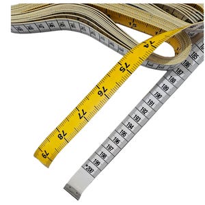 May include: A yellow and white measuring tape with numbers from 74 to 200. The tape is rolled up and the end is visible.