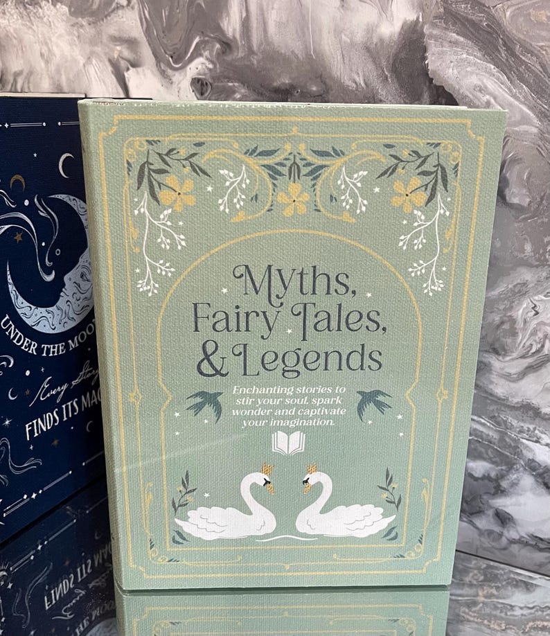 May include: A hardcover book titled "Myths, Fairy Tales, & Legends" with a light green cover. The cover features floral designs, two swans, and the text "Enchanting stories to stir your soul, spark wonder and captivate your imagination."