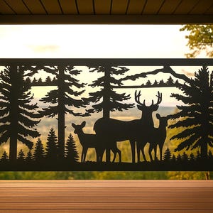 May include: A rectangular black metal privacy screen featuring a laser-cut silhouette design of a forest landscape with tall pine trees and a group of three deer, including a large buck with antlers, standing together in the center of the panel.