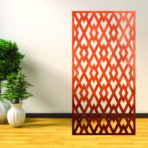 May include: A red metal room divider with a geometric pattern. The divider is standing in front of a white wall and a wooden floor.