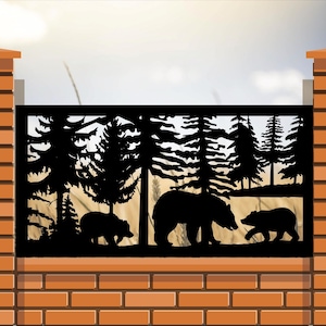 May include: A rectangular black metal fence panel featuring a laser-cut silhouette design of a forest landscape with three bears. The scene depicts a large bear walking between two smaller bears amidst tall pine trees, set against a light background.