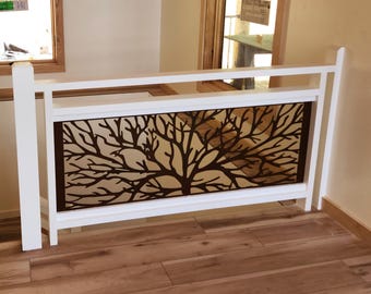 May include: White wooden railing with a brown metal tree design insert. The railing is mounted on a wooden staircase.