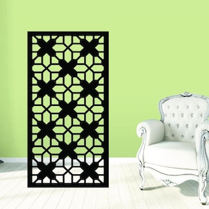 May include: A black metal room divider with a geometric pattern of interlocking squares and stars. The divider is shown against a light green wall and a white chair.