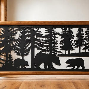 May include: A decorative wooden railing with a black metal panel featuring a forest scene. The panel depicts silhouettes of pine trees and three bears. The railing has a natural wood finish and is suitable for interior use.