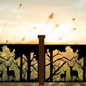 May include: A black metal fence panel with a silhouette of a forest scene featuring two deer. The fence panel is set against a blurred background of a sunset and tall grass.