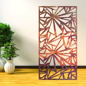 May include: A rusty metal room divider with a geometric pattern of triangles and lines. The divider is standing in front of a white wall and a wooden floor.
