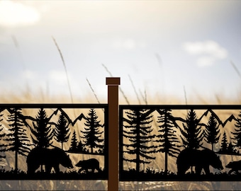 May include: Black metal fence panels with a nature scene featuring bears, trees, and mountains. The silhouettes are set against a blurred background of a field and sky. The fence posts are brown.