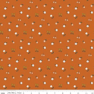 May include: A rust-colored fabric with a repeating pattern of small white flowers and green leaves.