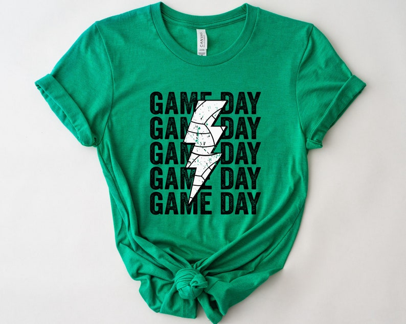 May include: Green t-shirt with a white lightning bolt graphic and the text "GAME DAY" repeated five times.