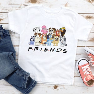 May include: White t-shirt featuring a graphic of cartoon dogs from the show "PAW Patrol" and the text "F.R.I.E.N.D.S".