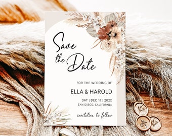 May include: Save the Date card with a beige background and a floral design featuring dried pampas grass and flowers. The text reads "Save the Date" for the wedding of Ella & Harold on Saturday, December 17, 202X in San Diego, California. The card also includes the text "invitation to follow".