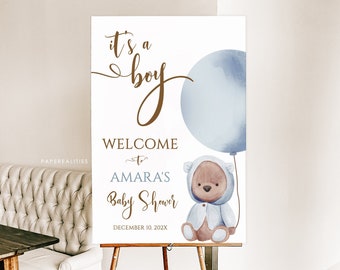 Könnte beinhalten: Ein Willkommens-Schild für eine Babyparty mit der Aufschrift "Es ist ein Junge" mit einem blauen Aquarell-Ballon und einem Teddybär, der einen blauen Kapuzen-Strampler trägt. Das Schild lautet "Willkommen zur Babyparty von Amara am 10. Dezember 202X".