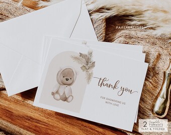 Puede incluir: Una tarjeta de agradecimiento con una ilustración de acuarela de un osito de peluche con un suéter con capucha. La tarjeta tiene un fondo beige con texto marrón que dice "gracias por llenarnos de amor".