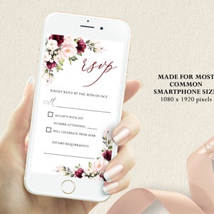 May include: A white and pink floral design with a burgundy accent on a smartphone screen. The screen displays a wedding RSVP card with the text "Esop" and "Kindly reply by the 30th of Oct". The card includes checkboxes for "Accepts with Joy", "Number Attending", and "Will Celebrate from Afar".