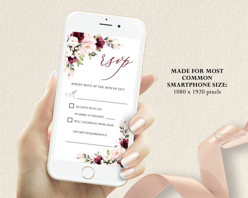 May include: A white and pink floral design with a burgundy accent on a smartphone screen. The screen displays a wedding RSVP card with the text "Esop" and "Kindly reply by the 30th of Oct". The card includes checkboxes for "Accepts with Joy", "Number Attending", and "Will Celebrate from Afar".