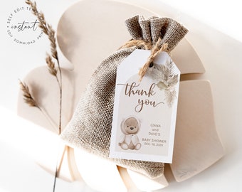 Peut inclure: Une étiquette de remerciement marron et blanche avec un ours en dessin animé portant une veste à capuche blanche. L'étiquette porte le texte "merci" en cursive et le texte "Liana et Dave's Baby Shower Dec. 18, 202X".
