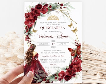 May include: A Quinceañera invitation with a gold and red floral design. The invitation features a gold crown, butterflies, and the text "Victoria Anne". The event is scheduled for December 17th at 2 PM. The invitation includes the location of the ceremony and reception.