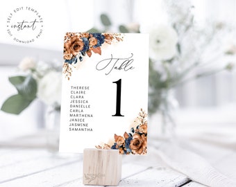 Puede incluir: Una tarjeta de número de mesa blanca con un diseño floral en tonos marrones y azules. La tarjeta tiene el texto "Mesa 1" y una lista de nombres: Therese, Claire, Clara, Jessica, Danielle, Carla, Marthena, Janice, Jasmine, Samantha.