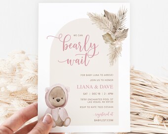 May include: A baby shower invitation with a watercolor illustration of a teddy bear wearing a pink hooded sweater. The invitation says "We can bearly wait" for baby Luna to arrive. The invitation includes the date, time, and location of the shower, as well as the names of the parents-to-be, Liana and Dave.