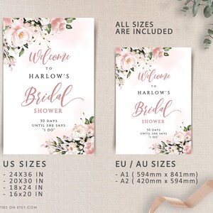 Op de afbeelding: Een afdrukbaar bruiloftsshowerbord met roze bloemenontwerpen en de tekst "Welkom bij Harlow's Bridal Shower 30 dagen tot ze 'Ja' zegt" Het bord bevat US en EU/AU maten in inches en millimeters.