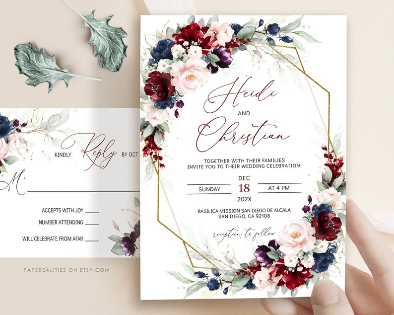 May include: Wedding invitation with a burgundy, blush, and navy floral design. The invitation features a gold geometric frame and the text "Heidi and Christian" with the wedding date and location.