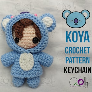 May include: Crochet pattern for a Koya keychain. The pattern features a blue and white crocheted character with a brown hair and a cute face. The pattern is available for download.