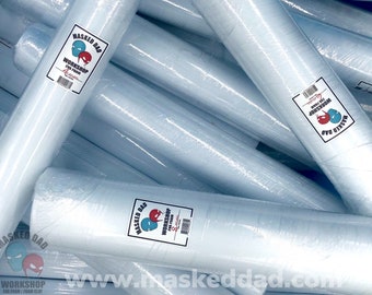 Może przedstawiać: Stos białych rolek gliny piankowej, każda owinięta w przezroczysty plastik. Rolki mają etykietę z tekstem "Masked Dad Workshop EVA Foam/Foam Clay" i logo dwóch postaci w maskach.