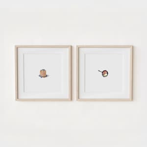 May include: Two framed illustrations of breakfast foods. The left frame shows a stack of pancakes with blueberries on top. The right frame shows a frying pan with a fried egg and bacon.