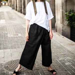 Unisex linen culottes in black paired with a white linen top featuring elbow-length sleeves