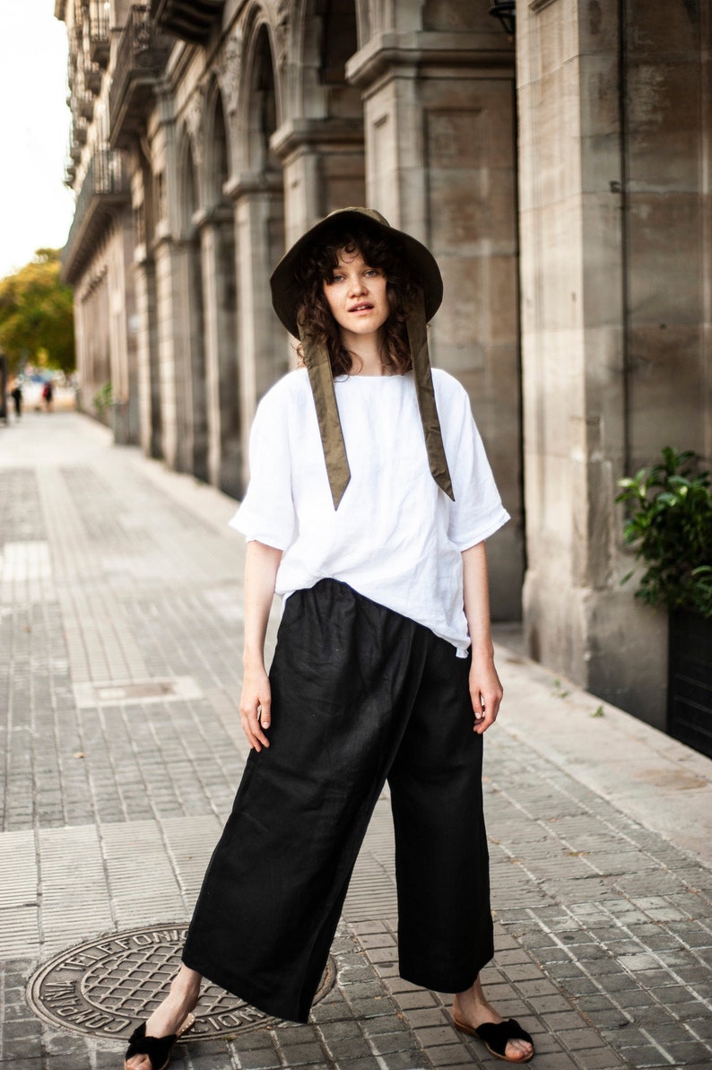 Unisex linen culottes in black paired with a white linen top featuring elbow-length sleeves