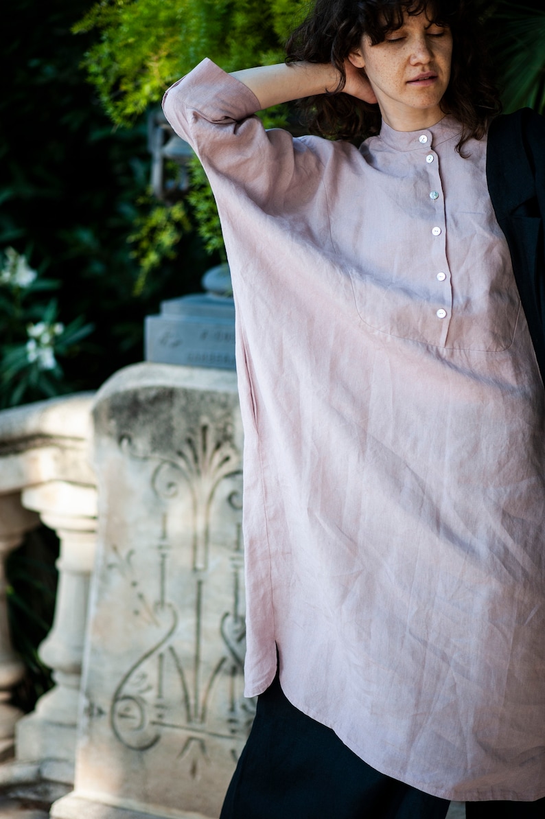 Oversized linen tunic with three-quarter sleeves, side pockets, and a band collar. Kaftan-inspired construction offering ample space for the arms and chest