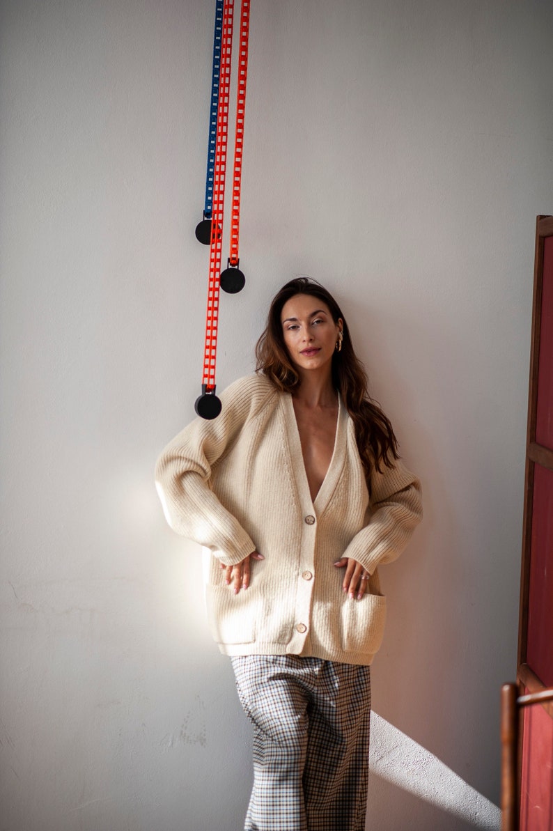 Natural white merino wool cardigan with front pockets and raglan sleeves
