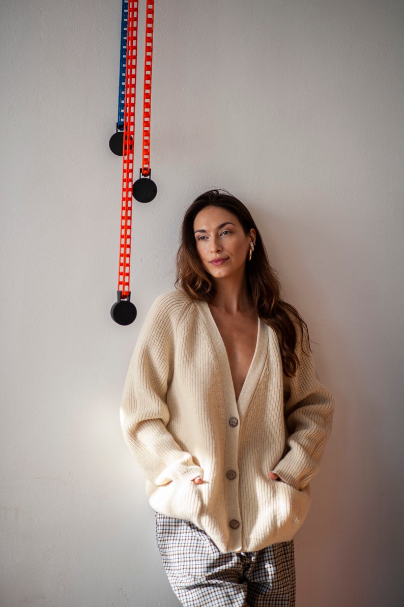 Oversized merino wool sweater with raglan sleeves, front pockets and coconut buttons