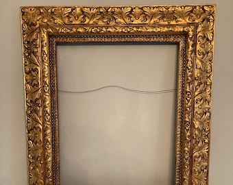 Puede incluir: Un marco de imagen grande, adornado, de color dorado con un diseño floral tallado detallado.