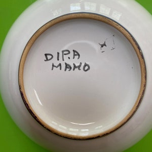 Pode incluir: Tigela de cer&acirc;mica branca com borda dourada e uma inscri&ccedil;&atilde;o manuscrita na parte inferior que diz "DIPA MAHO".