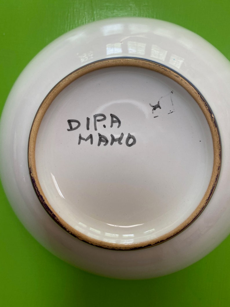 Pode incluir: Tigela de cer&acirc;mica branca com borda dourada e uma inscri&ccedil;&atilde;o manuscrita na parte inferior que diz "DIPA MAHO".