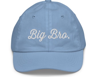 May include: A light blue baseball cap with a curved brim. The words "Big Bro." are embroidered in white cursive across the front of the cap. The cap has a six-panel design with a button on top.