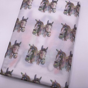 May include: White tissue paper with a repeating pattern of watercolour horse heads. The horses are brown and white with black bridles.