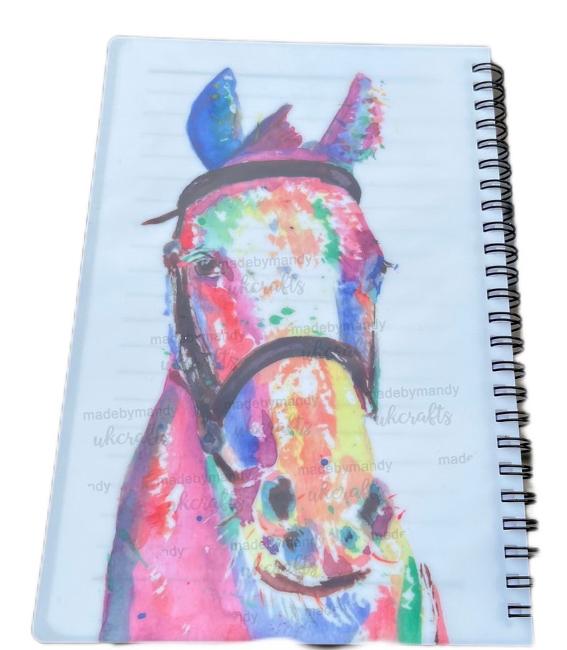 May include: A colourful watercolour painting of a horse's head with a black bridle. The horse's coat is painted in shades of pink, blue, yellow, and green. The background is white.