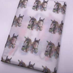 May include: White tissue paper with a repeating pattern of watercolour horse heads. The horses are facing forward and have brown, black, and white markings.