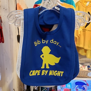Infant bib: bib by day, cape by night, 100% cotton with hook and loop closure. Baby humor | superhero | caped crusader | baby boss