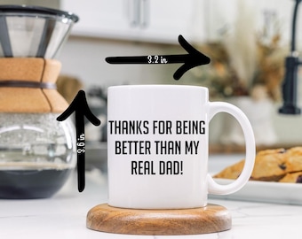 May include: White ceramic mug with black text that reads "Thanks for being better than my real dad!" The mug is 9.1 cm tall and 8.1 cm wide.