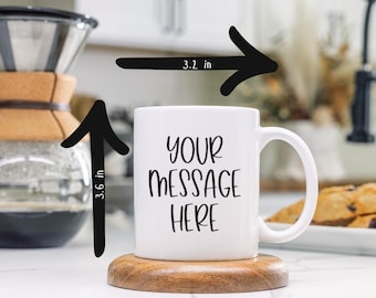 May include: White ceramic mug with a black handle. The mug is 3.6 inches tall and 3.2 inches wide. The mug has the text "YOUR MESSAGE HERE" printed on the front.