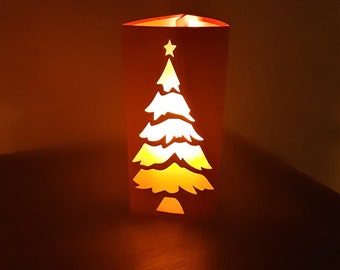 May include: A paper lantern shaped like a Christmas tree with a star on top. The lantern is lit from inside, casting a warm glow.