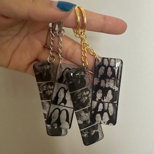 May include: Three rectangular keychains with black and white photo booth strip images. The keychains have gold and silver-colored chains and rings. The photos show multiple women in various poses.
