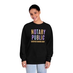 May include: Black long-sleeve shirt with the text "NOTARY PUBLIC CERTIFIED SIGNING AGENT" in colorful letters.